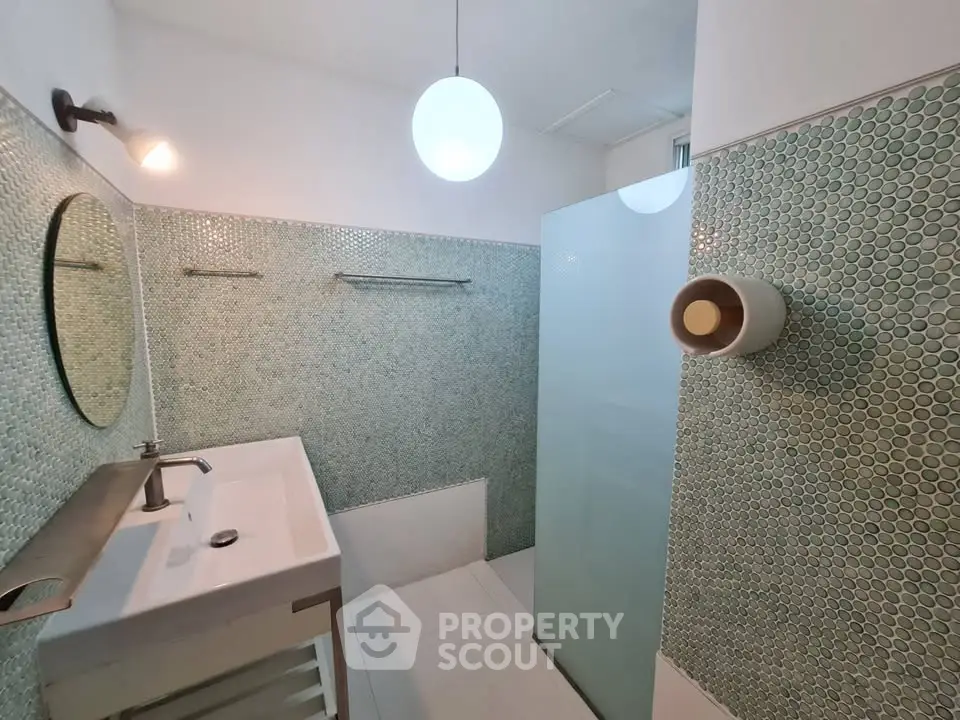 Modern bathroom with stylish green mosaic tiles and sleek white fixtures