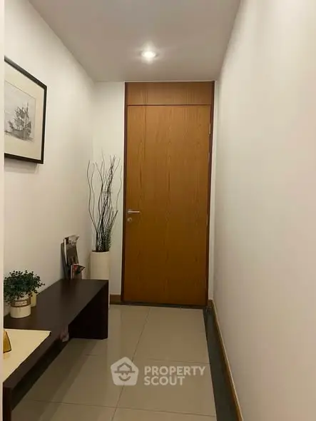 Modern hallway with wooden door and stylish decor in a contemporary apartment.