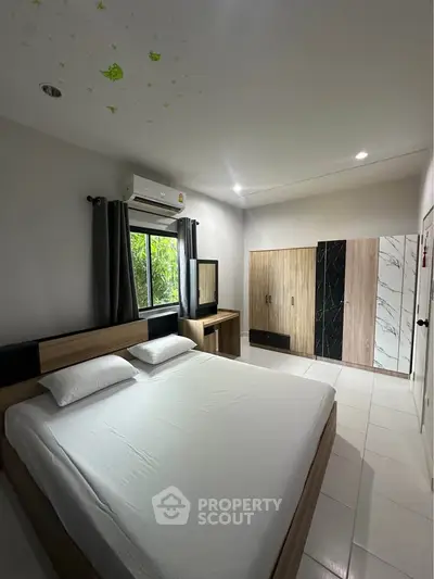 Spacious bedroom with modern decor and large window view