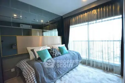 Luxurious bedroom with large window and modern decor in a high-rise apartment.
