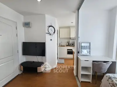 Modern studio apartment with open kitchen and cozy living area, featuring sleek furniture and natural light.
