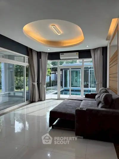 Luxurious living room with modern sofa and pool view, perfect for relaxation.