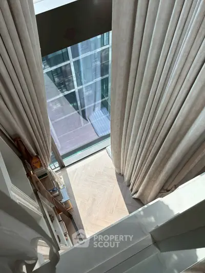 Luxurious high-rise apartment with floor-to-ceiling windows and elegant curtains, offering a stunning city view.