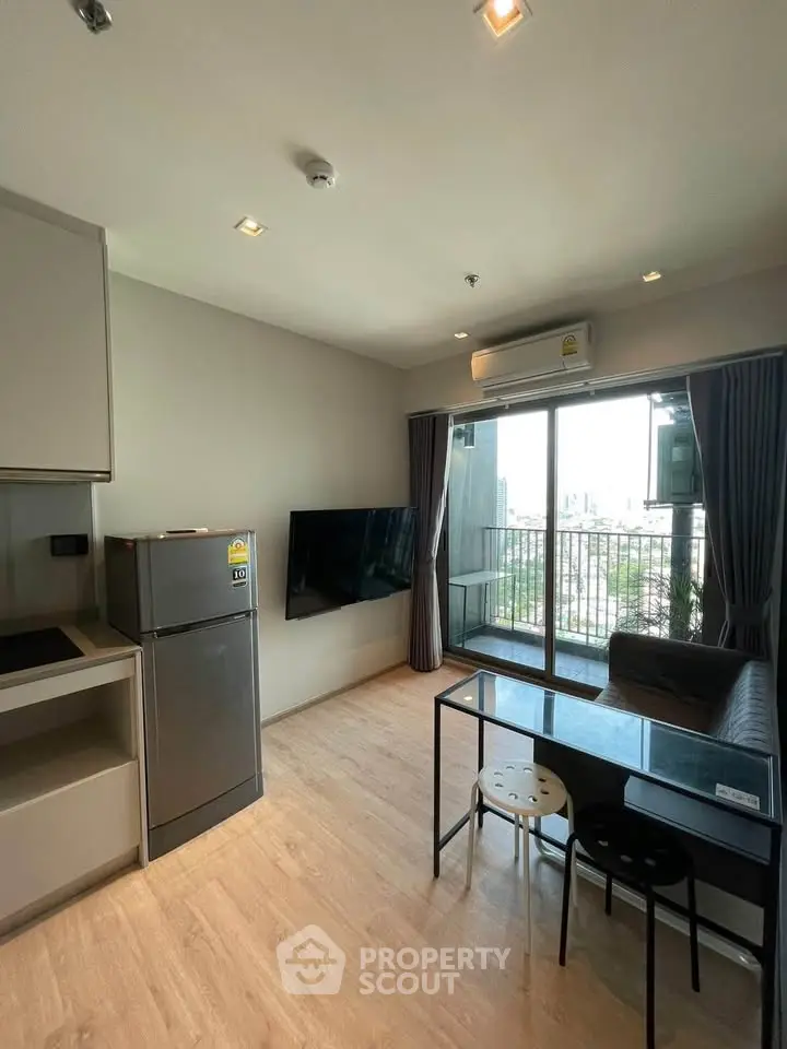 Modern living room with balcony view, sleek furniture, and natural light in a stylish apartment.
