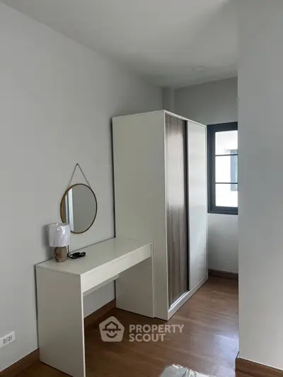 Modern bedroom with sleek wardrobe and stylish desk, perfect for urban living.