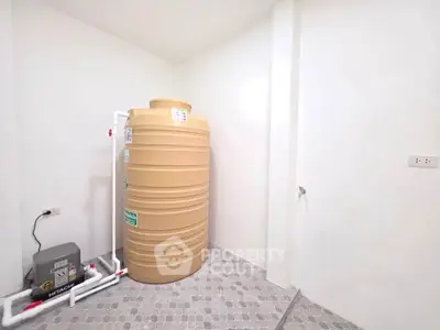 Spacious utility room with large water tank and tiled flooring