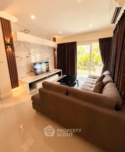 Luxurious living room with elegant marble wall and plush sofa, overlooking a lush garden through large windows.