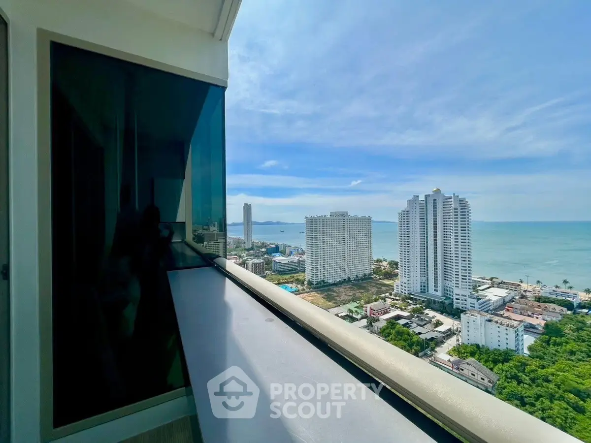 Stunning ocean view from high-rise balcony overlooking cityscape and coastline.