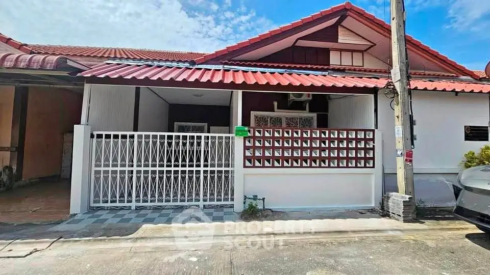 Charming single-story house with red roof and gated front yard in a serene neighborhood.