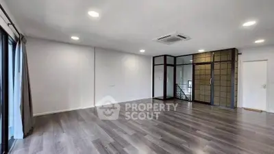 Spacious modern living room with sleek flooring and large windows for natural light.