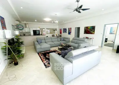 Spacious modern living room with stylish gray sofas and open kitchen layout