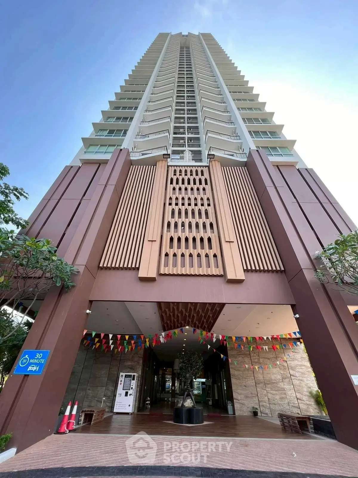 Stunning high-rise building entrance with modern architectural design and vibrant flags.