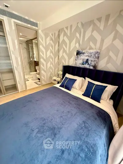 Modern bedroom with stylish decor and ensuite bathroom in luxury apartment.