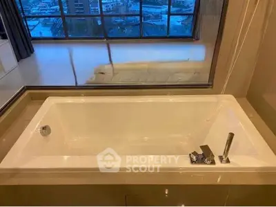 Luxurious bathroom with a modern bathtub and stunning city view through large windows.