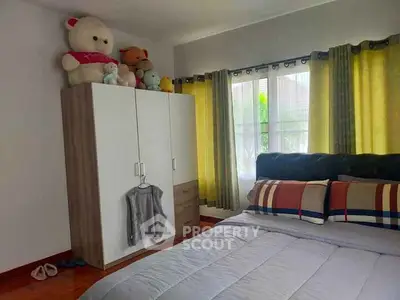 Cozy bedroom with plush toys on wardrobe and stylish bedding