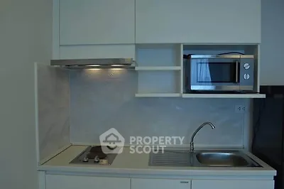 Modern compact kitchen with sleek cabinetry and built-in microwave