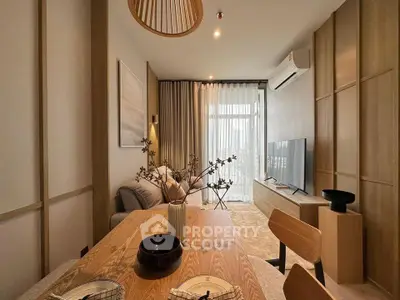 Modern living room with stylish decor and natural light, featuring a cozy dining area and sleek TV setup.