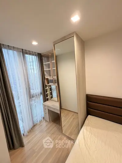 Modern bedroom with floor-to-ceiling windows and built-in wardrobe in a high-rise apartment.