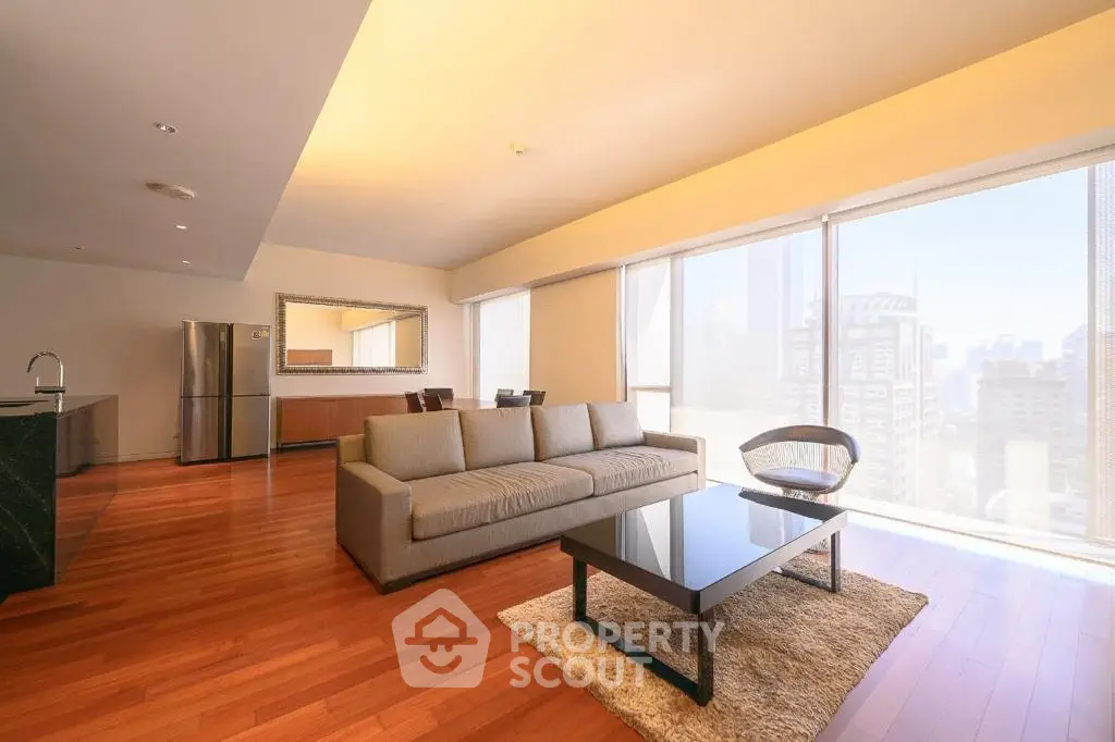 Spacious modern living room with city view, hardwood floors, and elegant furniture in a luxury apartment.