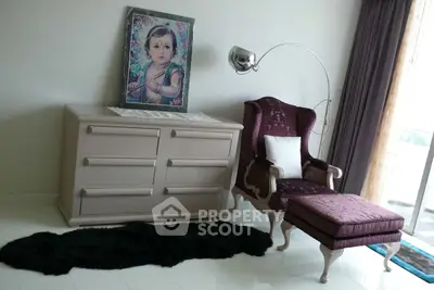 Elegant living room with vintage armchair, modern dresser, and floor lamp, perfect for stylish relaxation.