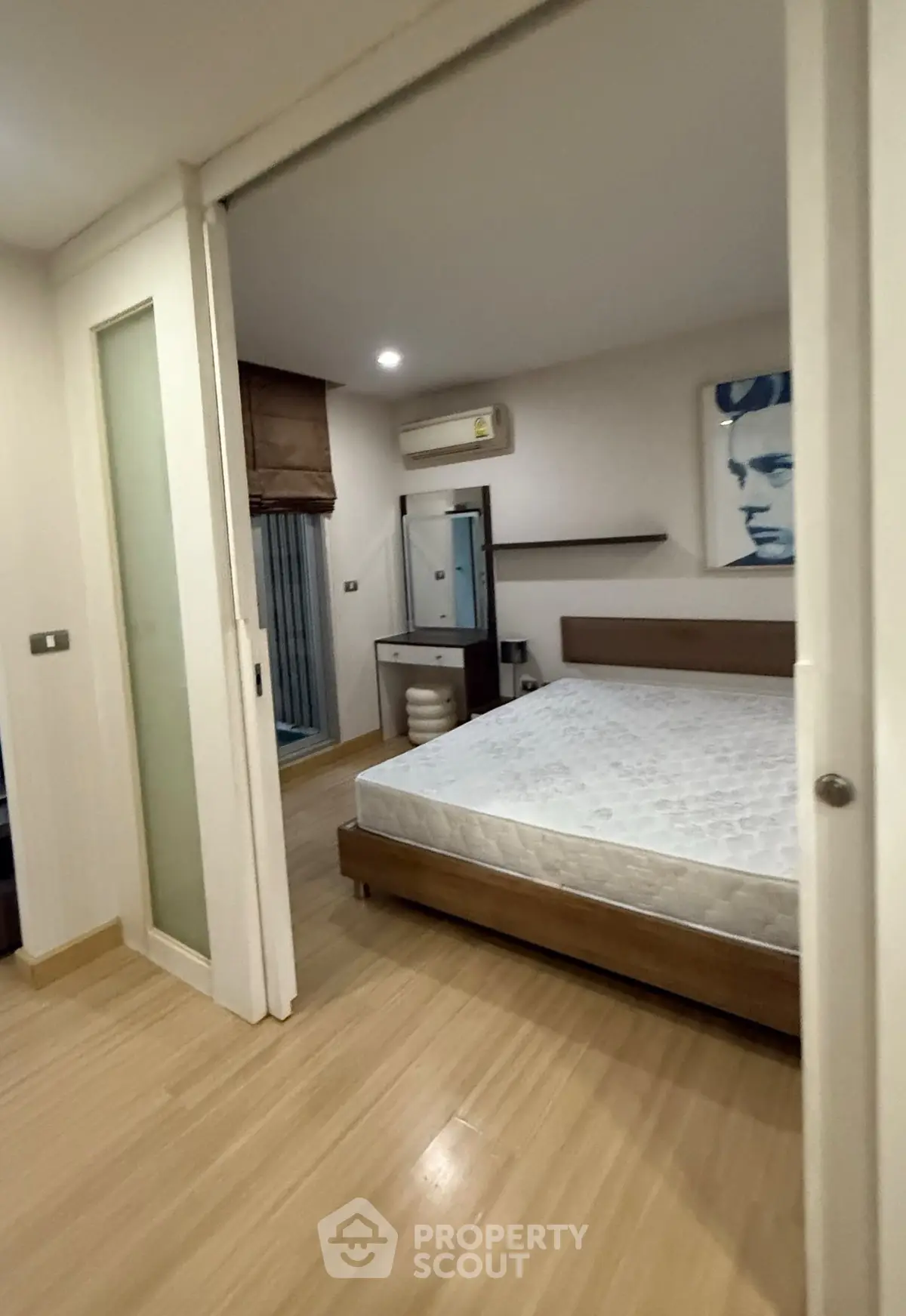 Modern bedroom with wooden flooring and stylish decor in a cozy apartment.