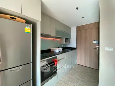 Modern kitchen with sleek cabinetry and built-in oven in a stylish apartment.