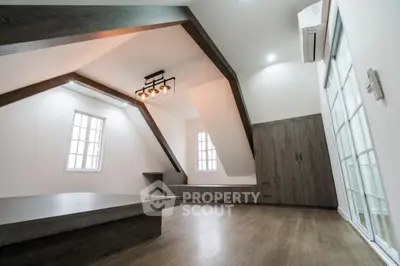 Modern attic bedroom with stylish wooden flooring and unique ceiling design