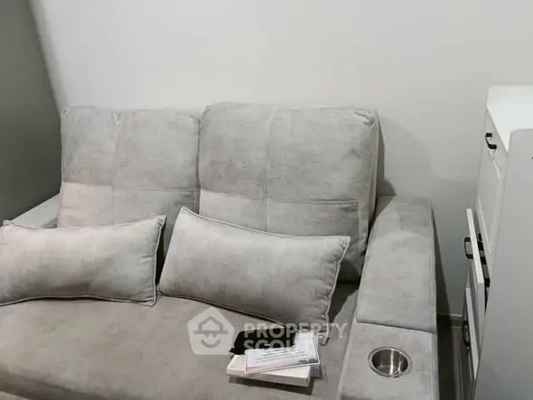 Cozy living room with plush gray sofa and modern storage unit.
