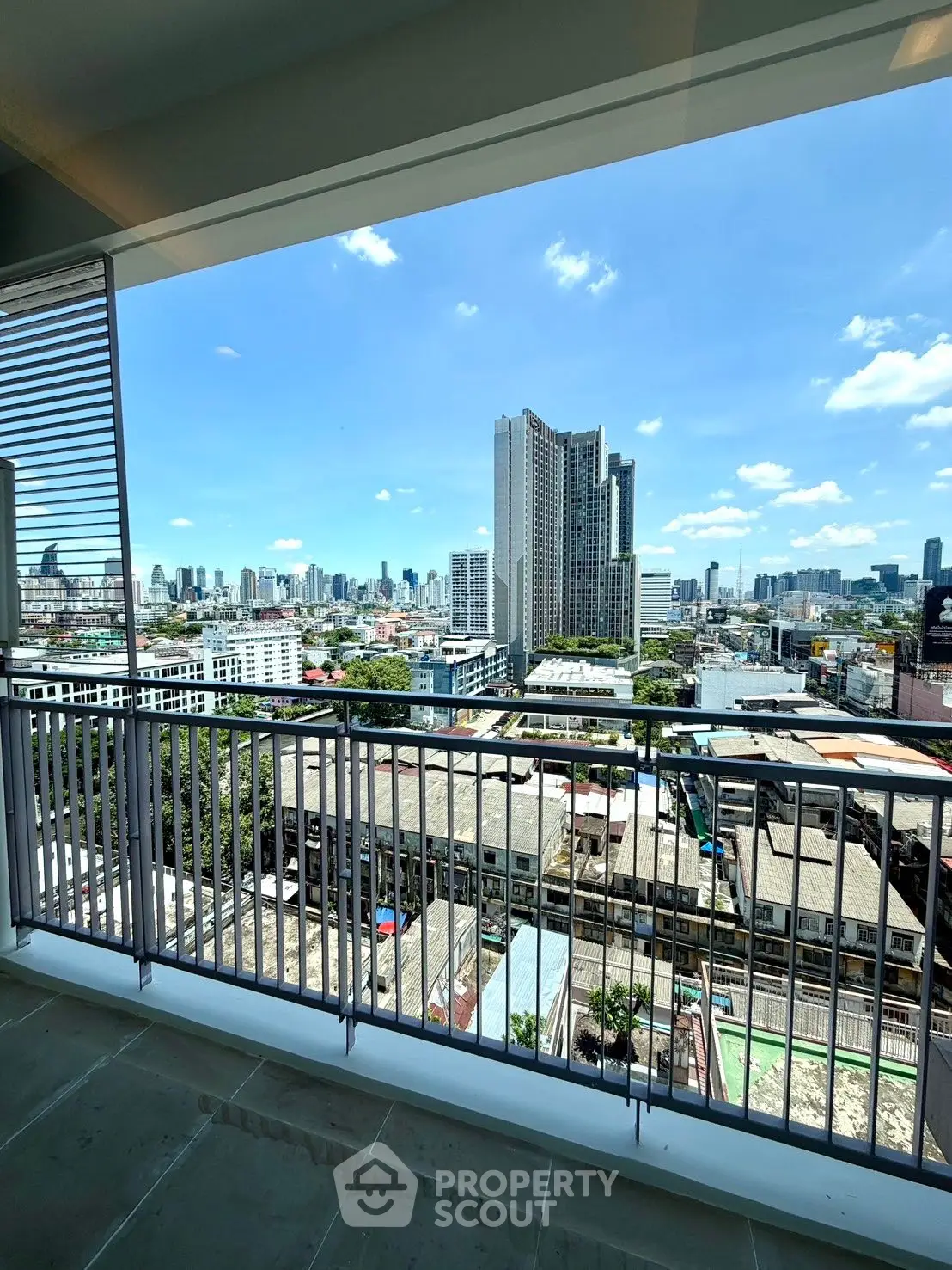 Stunning cityscape view from a spacious balcony in a modern high-rise apartment.
