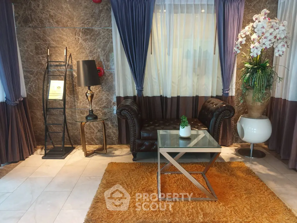 Elegant living room with plush sofa, glass coffee table, and luxurious decor