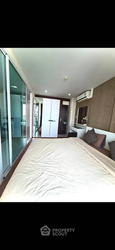 Modern bedroom with large windows and stylish decor in a contemporary apartment.