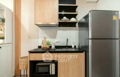 Modern kitchen with sleek appliances and stylish wooden cabinetry.
