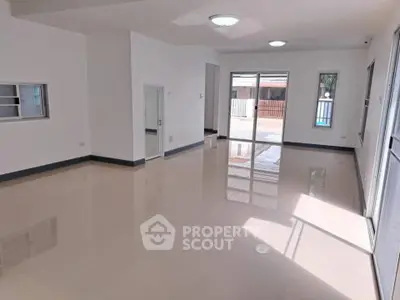 Spacious modern living room with glossy floors and ample natural light.