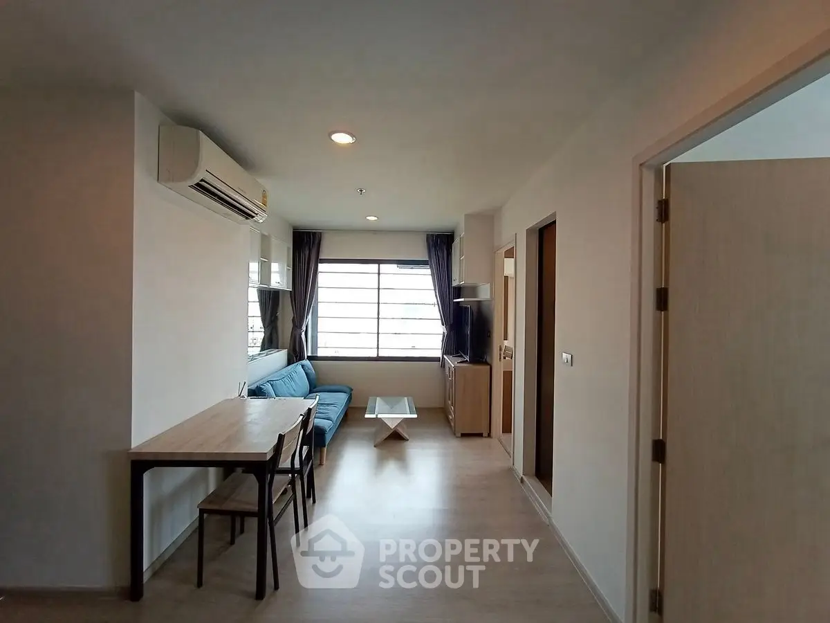 Modern living room with natural light, featuring a cozy sofa and dining area, perfect for urban living.