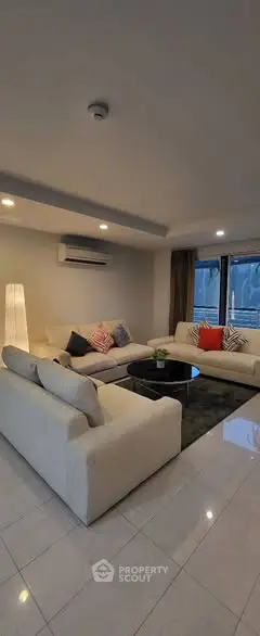 Spacious modern living room with elegant L-shaped sofa and ambient lighting.