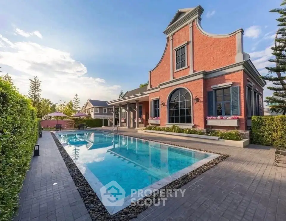 Stunning brick house with elegant pool and lush garden, perfect for luxury living.