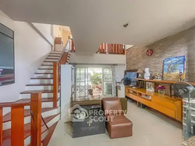 Spacious living room with modern decor and open staircase, perfect for family gatherings.