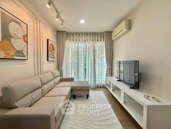 Modern living room with stylish decor, large sofa, and flat-screen TV, perfect for relaxation and entertainment.