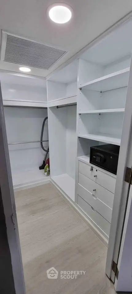 Spacious modern storage room with built-in shelves and safe