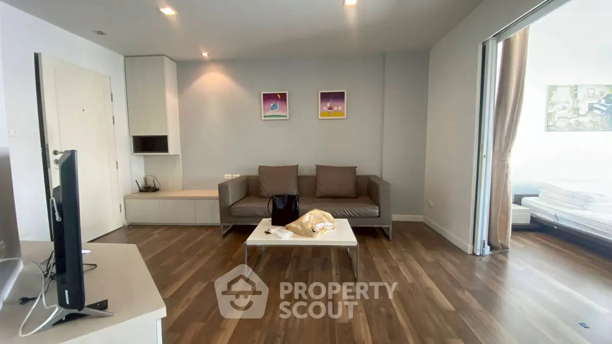 Modern living room with sleek wooden flooring and stylish furniture