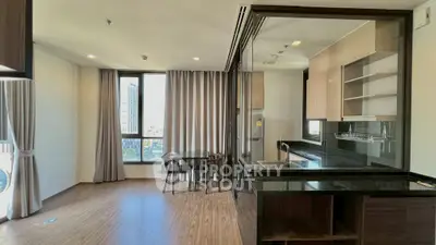 Modern open-plan living room with sleek kitchen and city view, perfect for urban living.