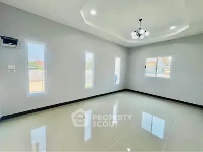 Spacious and bright living room with modern lighting and large windows.