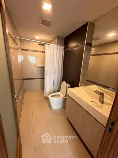 Modern bathroom with sleek fixtures and elegant tile design, featuring a spacious shower and contemporary vanity.