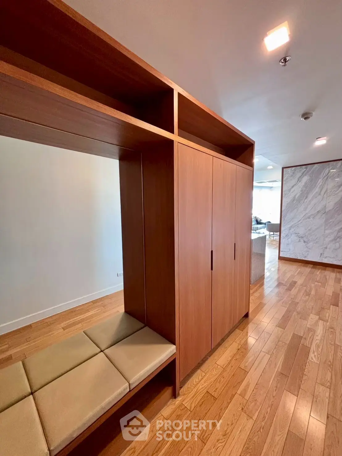 Spacious modern interior with wooden flooring and built-in storage bench.