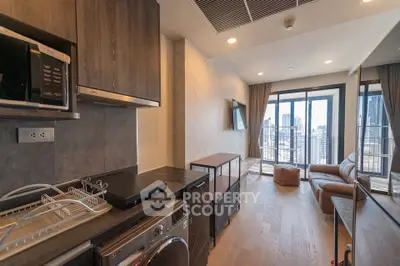 Modern living room with city view, featuring sleek furniture and in-unit laundry appliances.