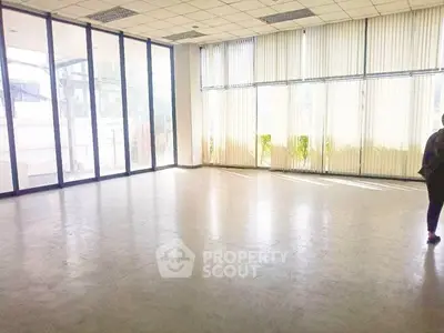 Spacious empty room with large windows and abundant natural light, ideal for versatile use.