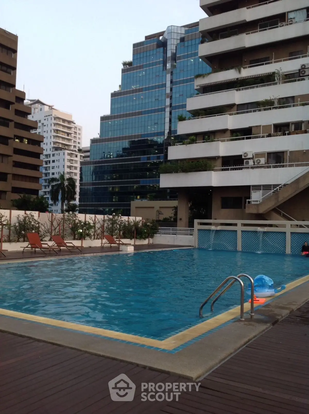 Luxurious residential pool area with modern high-rise buildings in the background.
