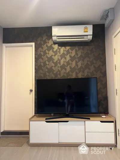 Modern living room with stylish TV setup and air conditioning unit