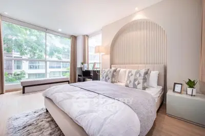 Luxurious bedroom with modern decor and large windows offering natural light.
