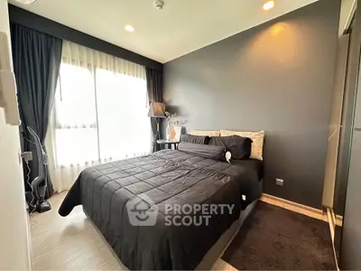Modern bedroom with dark accent wall and large window, featuring stylish decor and cozy ambiance.
